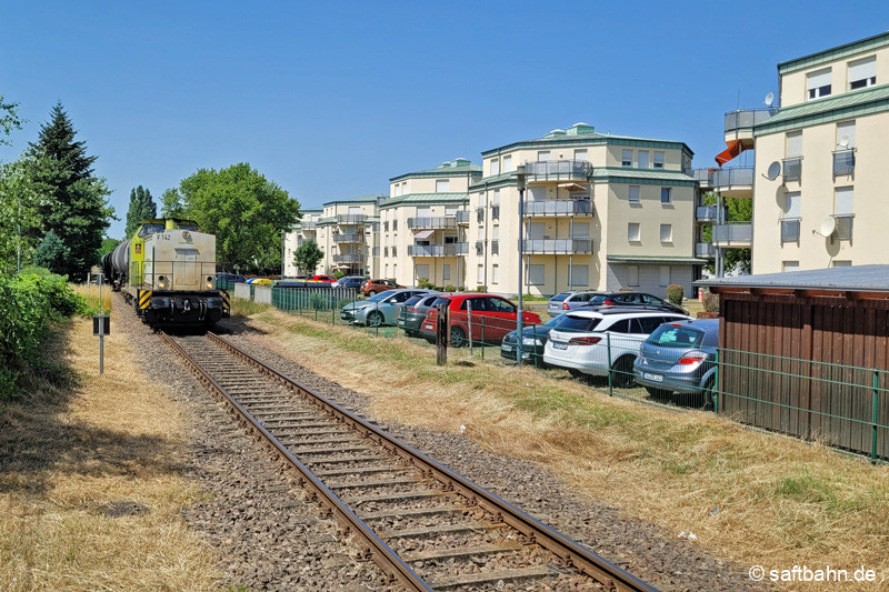Mit ihrer kurzen Ethanolwagengruppen am Haken durchfährt V142 die Stadt Sandersdorf.