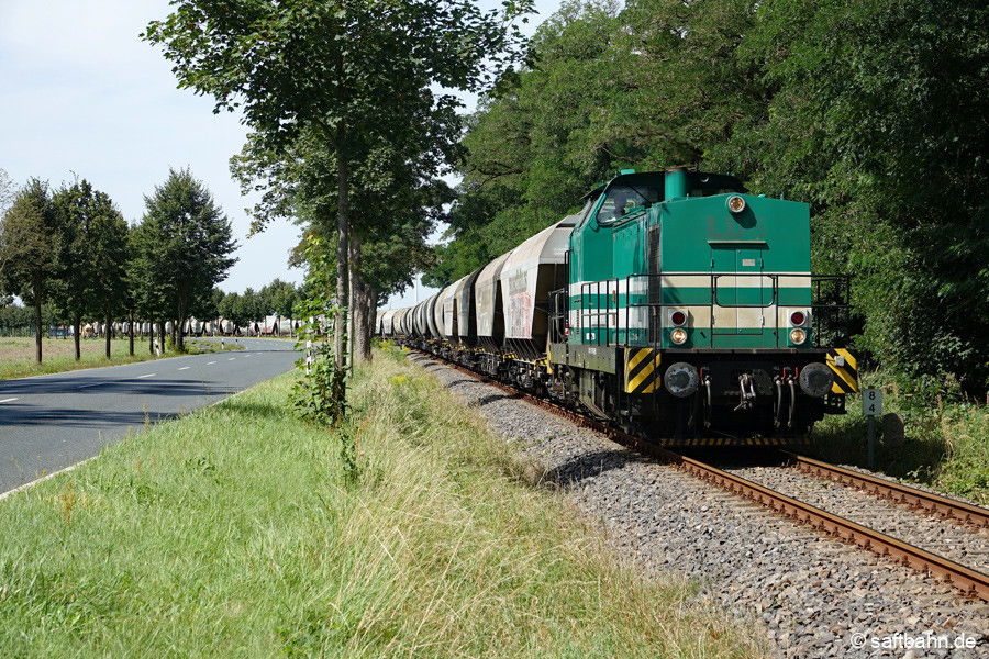 V140 zieht am Mittag den sichtbar langen Körnerleerzug von Zörbig nach Bitterfeld. Hinter Heideloh entstand diese Aufnahme.