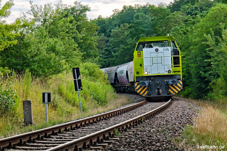 Eine im Mai 2025 Hauptuntersuchte G1206,allias 1115, schiebt die Getreidewagengruppe die Steigung hinauf gen Sandersdorf.
