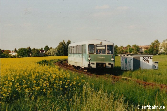 Recht weit voran geschritten war am 21.05.2001 die Rapsblüte auf einer Landwirtschaftfläche in Zörbig, als der Triebwagen 771 024-7 mit einer Regionalbahn in Richtung Stumsdorf die Stelle passierte. Im Mai 2009 endet das Betriebsgleis am Bahnübergangsposten 19 mit einem Prellbock als Gleisabschluss.