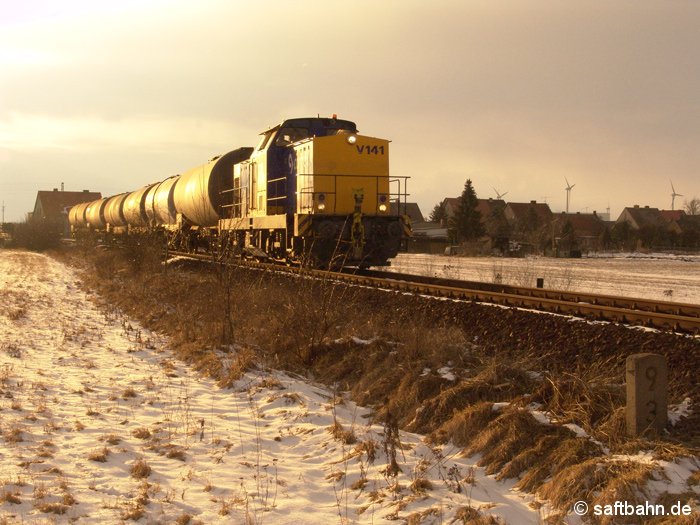 Der Abendsonne entgegen: Aus Richtung Zörbig ist der kurze Biokraftstoffzug mit Diesellok V141 unterwegs. In Heideloh befährt der Zug am 13.03.2006 das noch nicht sanierte Bahngleis in Richtung Bitterfeld, welches erst in den darauffolgenden Sommermonaten oberbautechnisch durchgearbeitet wird.