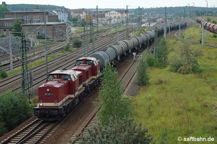 In Bitterfeld verlassen am 10.09.2011 die beiden V100 Maschinen 202 425 mit 202 484 der Leipziger Eisenbahnverkehrsgesellschaft dem Ethanolzug aus Zörbig den Bahnhof. Gut zu erkennen ist das mittige Saftbahn-Gleis nach Stumsdorf, welches zu diesem Zeitpunkt schon mit einem Prellbock zur Absicherung versehen war.