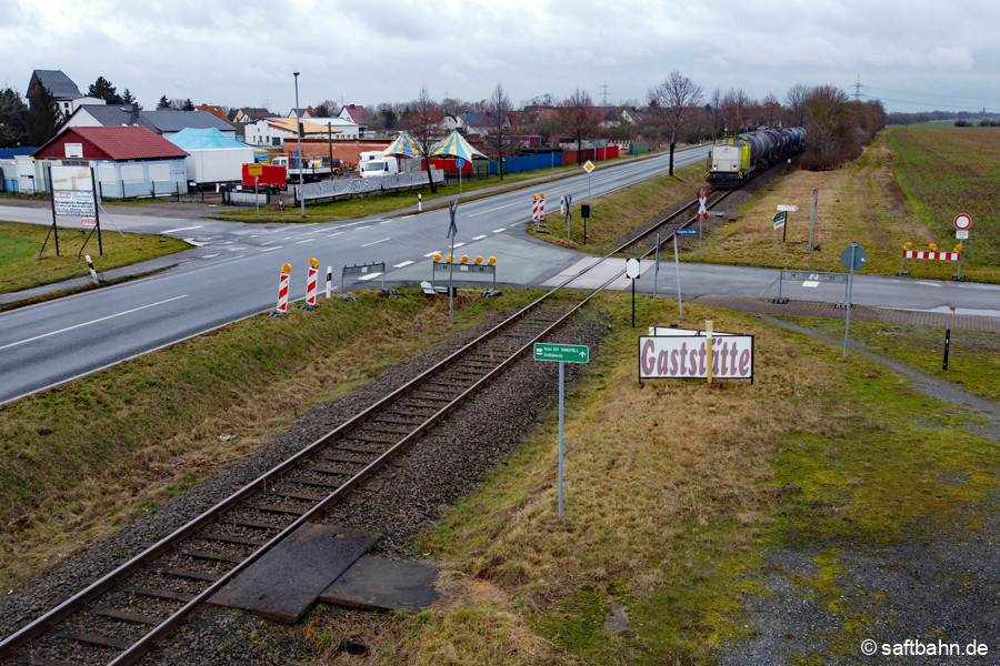 Unmittelbar vor der Sperrung und Sanierung des Bahnübergangs zum Großzöberitzer Gewerbegebiet, nähert sich am 22.01.2022 Lok V141 mit einem Bioethanolzug nach Bitterfeld.
Gut zu erkennen sind die verlegten Betonplatten am Bahngleis. Sie dienten einst dem Zugbegleiter zum Ausstieg, um den Bahnübergang mit Handfahne zu sichern.